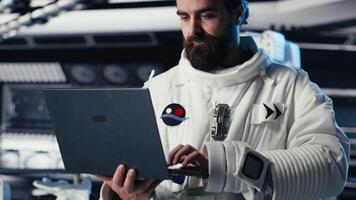 Astronauts in advanced technology spacecraft working together to update red planet updating flight log during routine mission check. Orbit station crew colleagues looking at system diagnostics video