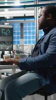 Vertical Black industrial specialist examining the assembling process on pc, working on clean sustainable energy by creating solar panel factory. Engineering innovation for production flow. Camera A. video