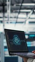 Vertical Software developer in data center uses AI technology on laptop to optimize storage volumes. IT expert in server hub facility using artificial intelligence to ensure seamless operations, camera B video