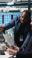 Vertical Diverse coworkers group in the factory handles solar power production line, showing teamwork in manufacturing systems of photovoltaics. Clean alternative energy management in plant. Camera A. video