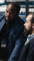 Vertical Factory supervisors diverse team sharing insight about production metrics, supporting industrial innovation and eco friendly clean energy development. Solar power improvement. Camera B. video