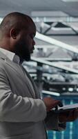 Vertical Smiling data center technician installing and upgrading hardware components. Happy server farm employee doing job tasks, implementing backup solutions to protect against data loss, camera B video