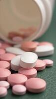 Different types of pills scattered on a green surface video