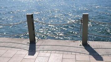 Waterfront view with shiny waves and a sturdy railing video