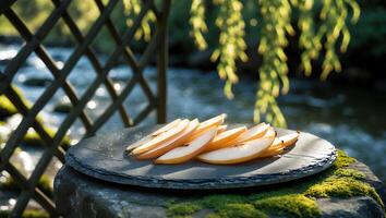 Sliced Pears on Slate Plate with River Background in Natural Setting photo