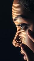 Person's face lit lines. Golden illumination over skin. Close up of eye, nose. Dark background and cybersecurity awareness. photo