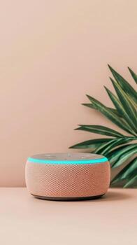 Wireless Speaker sits on surface with plant. Speaker glows with blue light. Simple background for Cybersecurity Awareness. photo