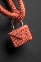 Red Letter Padlock Hanging from Rope on Dark Surface Promoting Cybersecurity Awareness Focus on Safety photo