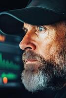 Man with beard looking at cybersecurity data. Person thinking about awareness. Screen displaying digital security information with graphs and charts. photo