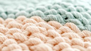 Close up fluffy yarn background. Peach and light green soft texture. Knitted material detail. Woven threads pattern. Macro pastel colored surface. photo