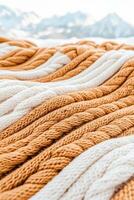 Close view braided texture gold white material. Woven pattern warm fabric with snowy mountains outdoor. Twisted cords abstract design. photo