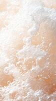 Water bubbles burst upward. White foam detail. Peach background. Sparkling liquid surface. Freshness and purity concept. Close up shot. Fluid motion. photo