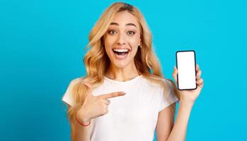 Millennial Woman Showing Phone with Blank Screen and Pointing On It, Blue Background photo