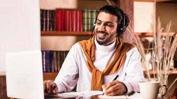 Cheerful Indian Teacher At Laptop Computer Teaching Online Having Remote Class With Distant Student Sitting Indoors, Working From Home. Modern Education And Tutoring, E-Teaching Training Concept photo