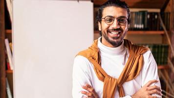 Online Distant Learning. Smiling Indian Teacher Guy Posing Near Blackboard With English Language Grammar Rules Standing At Home. Knowledge, Distance Teaching And Modern Education Concept. Copy Space photo