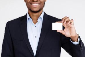 Cropped of black businessman handing blank business card on white background, panorama. Empty card in african american man hands, manager representing himself with business card, copy space photo
