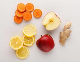 Healthy food. Ingredients for detox smoothie, ginger, carrot, apple, lemon on white background, top view, copy space. photo