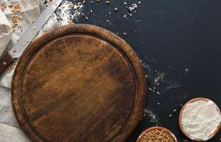 Baking background, flour on board at black. Bakery and home bread making concept. Copy space photo