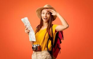 Amazed girl hiker with map doing sightseeing, yellow background photo