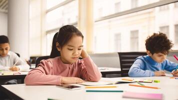 Learning Concept. Portrait Of Concentrated Japanese Schoolgirl Doing Homework Reading Book Or Notes In Her Copybook Sitting At Desk In Modern Classroom, Writing Test Thinking About Question, Banner photo