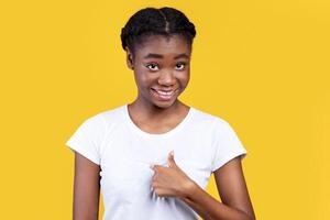 Choose Me. Smiling African American Young Woman Pointing Finger At Herself Posing Over Yellow Background. Studio Shot. Myself, Self-Confidence Concept photo