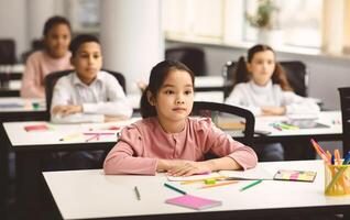Return Back To School. Portrait of focused diligent asian female pupil sitting with folded arms at desk with group of diverse classmates, listening to teacher, selective focus. Academic Concept photo