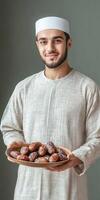 Arab man holding plate of dates photo