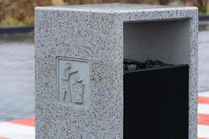 A modern concrete garbage container stands firm, encouraging responsible waste disposal and recycling photo