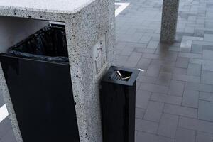 A sleek and contemporary garbage container stands in a bustling public area, designed to encourage responsible waste management photo