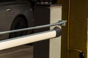 A sophisticated automatic gate mechanism is partially opened, allowing entry to a modern parking structure photo