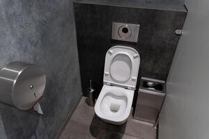 This modern restroom showcases a clean toilet in a minimalistic design. The sleek walls and neatly arranged fixtures promote a hygienic atmosphere photo
