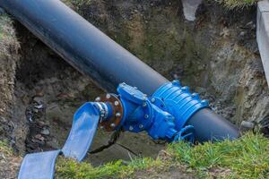 Workers are repairing a large water pipe nestled in a trench at a construction site. This vital infrastructure supports the water supply, showcasing the ongoing efforts in urban engineering photo