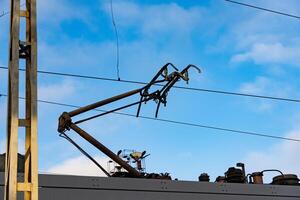 Metal structures reach for the sky, supporting rail wires that power trains, blending technology with the serene beauty of open space under a crisp blue sky, showcasing engineering brilliance photo