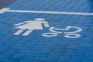 A blue-painted parking space features a clear symbol of a woman and a stroller, indicating designated parking for mothers with infants. This area promotes accessibility and convenience photo
