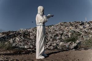 A figure dressed in protective gear surveys a sprawling landfill, highlighting the extensive impact of pollution on the ecosystem and the urgent need for better waste management practices photo