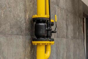 A brightly colored yellow and black gas pipeline connection illustrates the sophisticated technology used for transporting energy in industrial settings photo