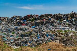 A vast expanse of a landfill reveals layers of trash including plastic, debris, and refuse, highlighting the environmental challenges posed by pollution and waste disposal practices photo