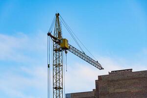 Two cranes are actively engaged at a large construction site, lifting materials high above the ground. This urban development project showcases industrial activity in a bustling skyline photo