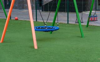 Colorful swings await children in a lively park setting, surrounded by inviting greenery and safe play areas. Kids can indulge in fun and playful activities, enjoying their time outdoors photo