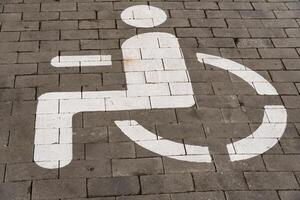 A clear symbol indicating wheelchair accessibility is marked on the ground. This sign is crucial for identifying designated parking areas for individuals with disabilities photo
