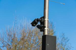 CCTV camera positioned on a sturdy pole oversees a public space, providing constant monitoring to ensure safety and security for the surrounding area photo