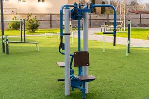 An outdoor gym machine designed for fitness training, situated on green grass in a public park. This equipment promotes healthy lifestyle choices and encourages community exercise routines photo
