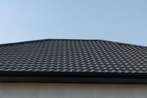 A striking roof adorned with patterned tiles reflects modern design, contrasting beautifully with the bright blue sky above. The geometry creates a sense of harmony and structure photo