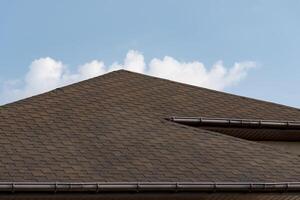 The distinct lines of a well-designed roof contrast against a vibrant blue sky, creating a tranquil atmosphere. Soft clouds gently drift in the background, enhancing the peaceful vibe photo