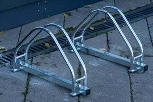 A shiny, metallic bicycle parking rack stands ready on a well-maintained surface, reflecting sunlight, perfect for cyclists looking to secure their bikes comfortably and safely photo