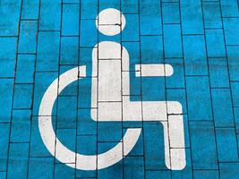 Bright blue pavement displays a clear accessibility symbol, promoting inclusivity in urban environments. This inviting marking encourages awareness and support for individuals with disabilities photo