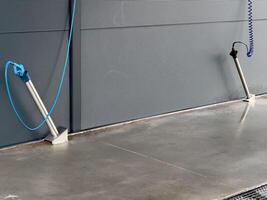 High-pressure washers are positioned for car cleaning, featuring hoses and nozzles, in a well-maintained car wash setting designed for efficient washing photo