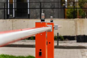 A closed barrier gate secures an entry point, restricting access to vehicles in a well-defined boundary of a contemporary urban area, ensuring safety and control photo