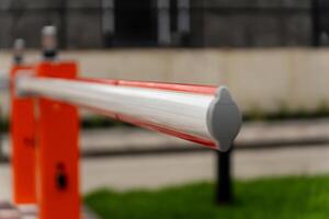 The barrier gate stands closed, marking the boundary for restricted access, ensuring security. Its bright colors and position indicate controlled entry during daytime photo
