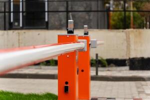 This bright orange barrier stands prominently, regulating entry to a secure location in a modern urban area. The strong design emphasizes security and control photo